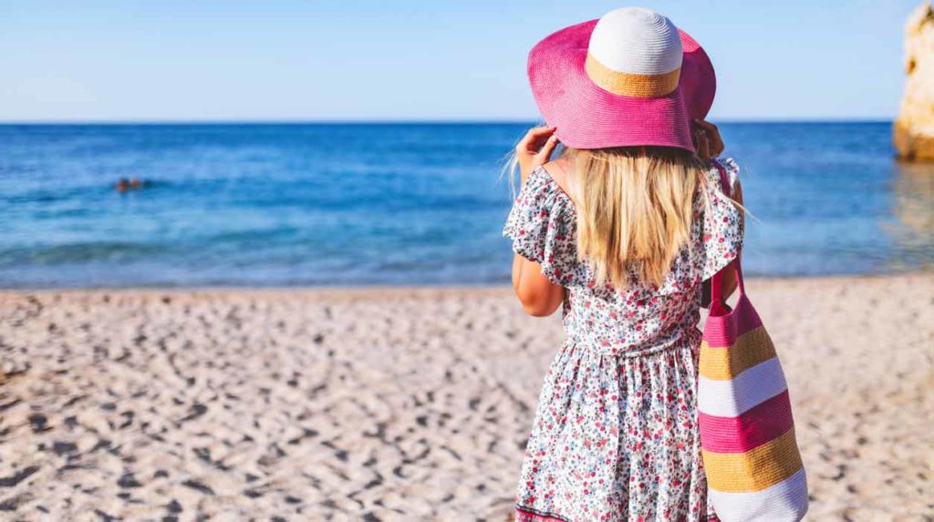 donna con borsa sulla spiaggia